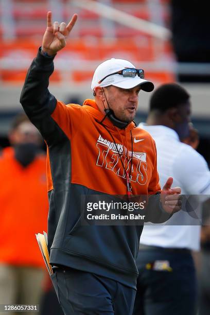 Head coach Tom Herman of the Texas Longhorns gives the Hook 'em Horns sign as he directs his team through drills before a game against the Oklahoma...