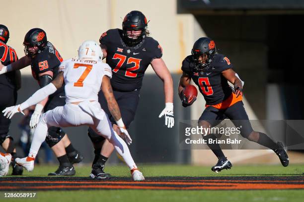 Running back LD Brown of the Oklahoma State Cowboys runs for a first down behind a block from left guard Josh Sills and center Ry Schneider against...