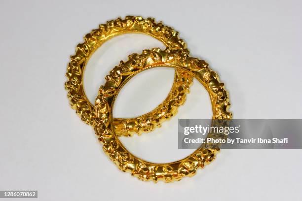 beautiful indian style gold bangles/jewelry laying on white background - bangle stock pictures, royalty-free photos & images