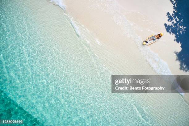 aerial view of transparent canoe boat with a girl relax in the tropical beach island with blue clear sea water that can see the coral reef under the sea water in summer season of thailand, asia - can beach sun photos et images de collection