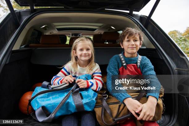 smiling cute siblings with luggage in car trunk - innocence stock pictures, royalty-free photos & images