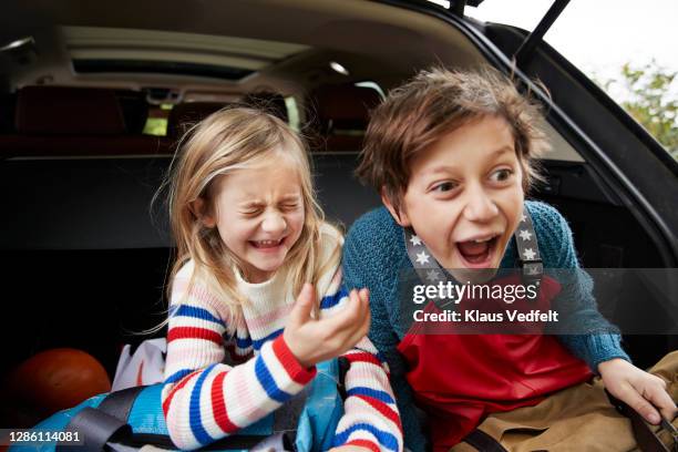 cheerful cute siblings with luggage in car trunk - boy playing with cars stock pictures, royalty-free photos & images