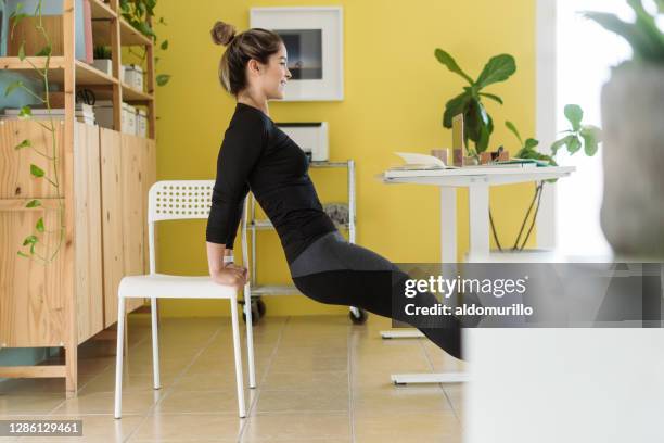gelukkige jonge vrouw die met stoel op het werk uitoefent - chair exercise stockfoto's en -beelden