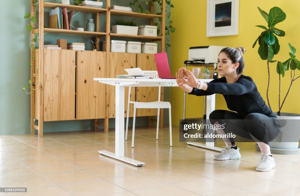 Young woman doing sit-ups at work