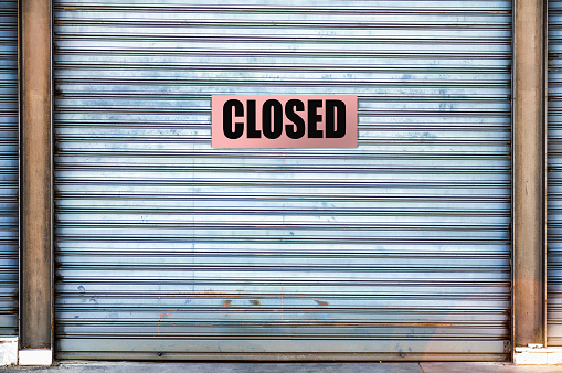 closed business with closed placard on roller shutter metal