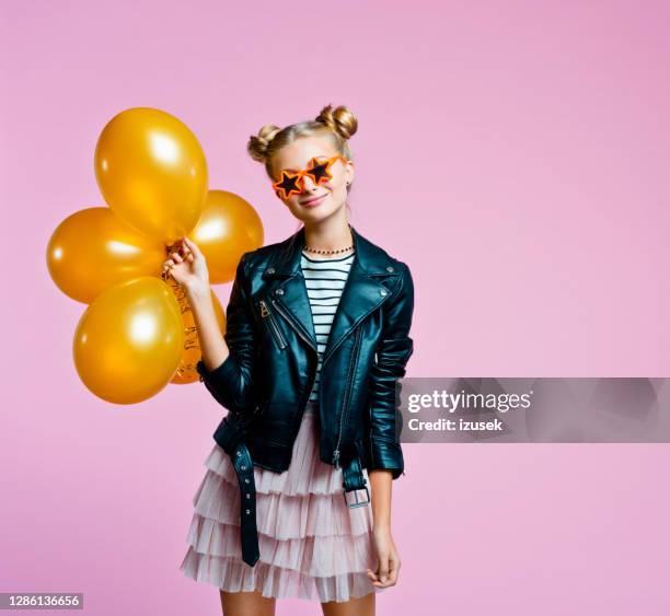 stylish teenege girl holding gold balloons - gold jacket stock pictures, royalty-free photos & images