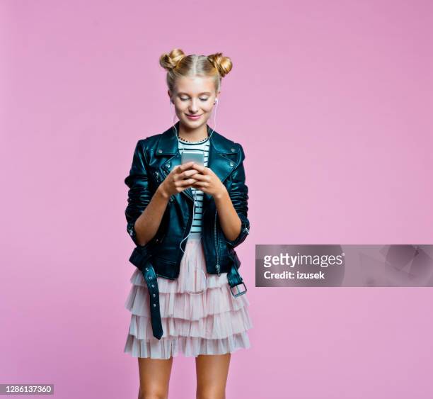 stylish teenege girl using smart phone - girl in leather jacket stock pictures, royalty-free photos & images