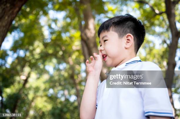 naughty boy picking snot in nose by his finger. cold virus, healthly lifestyle. - mucus stock pictures, royalty-free photos & images