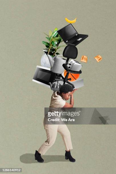 woman carrying stack of household items - sollevare foto e immagini stock