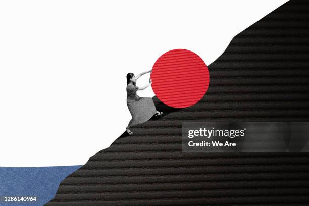 woman rolling object up hill - physical pressure stockfoto's en -beelden