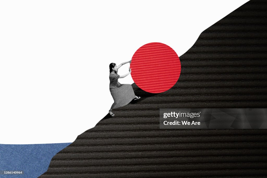 Woman rolling object up hill