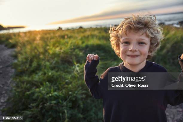 portrait of cute blond boy at the coast - blonde boys stockfoto's en -beelden