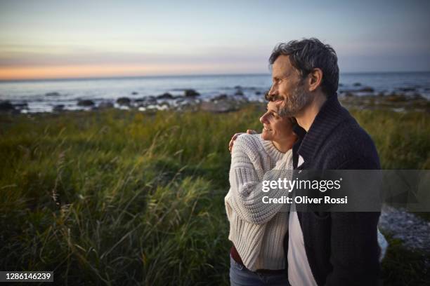 confident couple looking at view at the sea - older couple travelling ストックフォトと画像