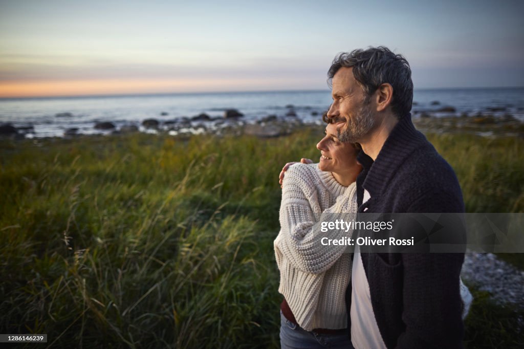 Confident couple looking at view at the sea