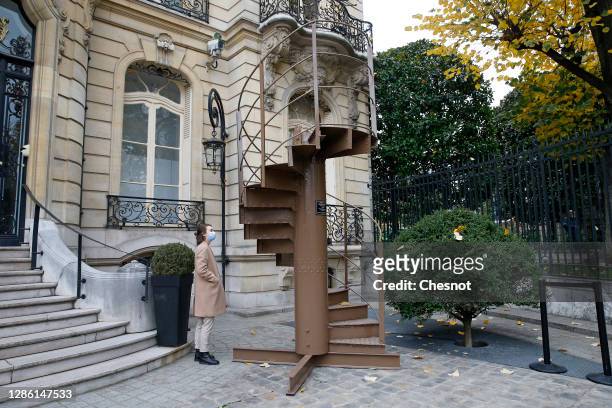 Woman looks at a section of stairs from the Eiffel Tower's original structure constructed by Gustave Eiffel in 1889 in the courtyard of the Artcurial...