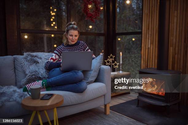 video call in cozy atmosphere - sitting by fireplace stock pictures, royalty-free photos & images