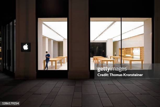 An employee wearing a protective face mask is seen in the closed Apple store in the popular Kaertner Strasse pedestrian shopping zone on the first...