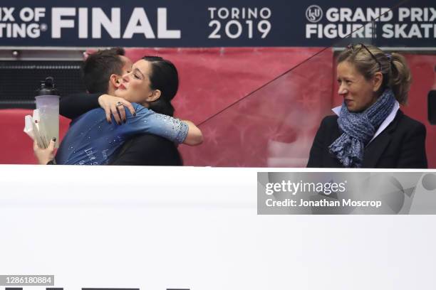Kevin Aymoz of France is embraced by his Italian coach Silvia Fontana, whilst Katia Krier looks on following his performance in the Men's Free...