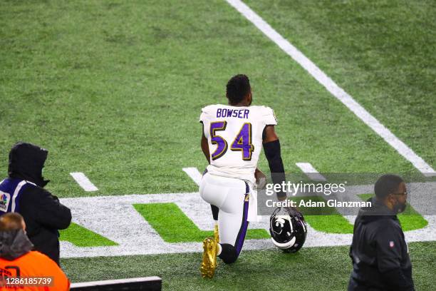 Tyus Bowser of the Baltimore Ravens kneels during the national anthem before a game against the New England Patriots at Gillette Stadium on November...