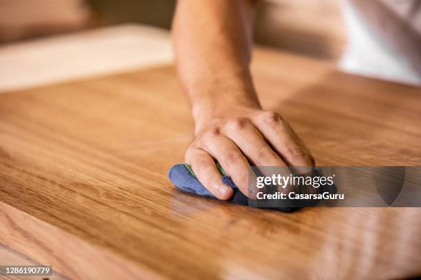 närbestängd av young carpenter gnugga olja into wood - spreading bildbanksfoton och bilder