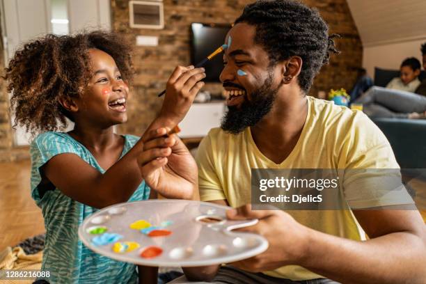 glücklicher vater und tochter malen zusammen zu hause. - african american dad stock-fotos und bilder