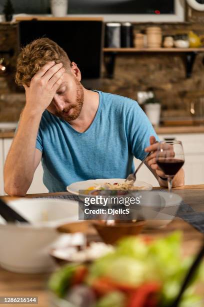 gedeprimeerde jonge mens die geen eetlust heeft om te eten. - eating alone stockfoto's en -beelden
