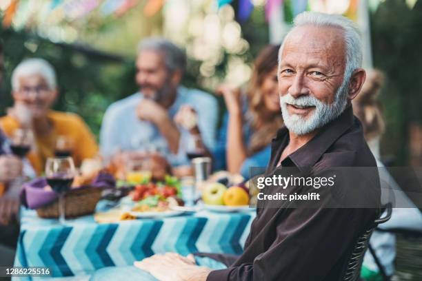 focus on a smiling senior man on a family celebration - old man party imagens e fotografias de stock