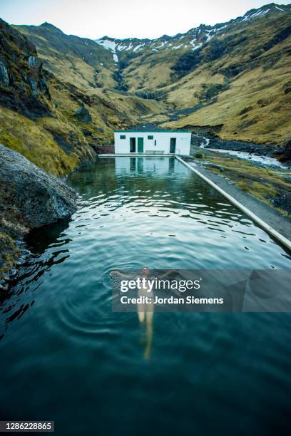 a woman swimming in a hot spring in iceland. - reykjavik stock-fotos und bilder