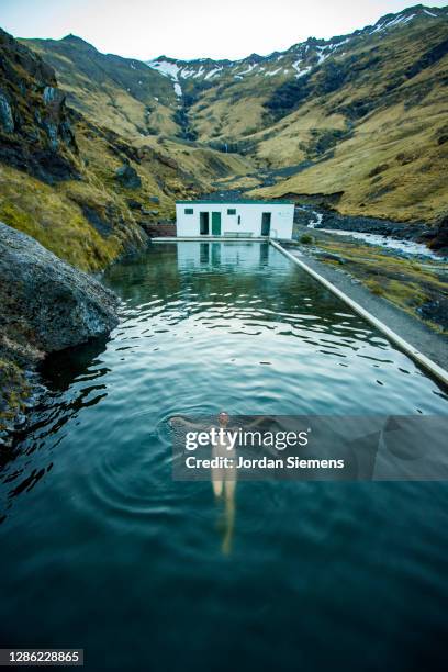 a woman swimming in a hot spring in iceland. - reykjavik iceland stock pictures, royalty-free photos & images