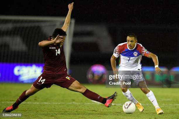 Alexis Sánchez of Chile competes for the ball with Luis Mago of Venezuela during a match between Venezuela and Chile as part of South American...