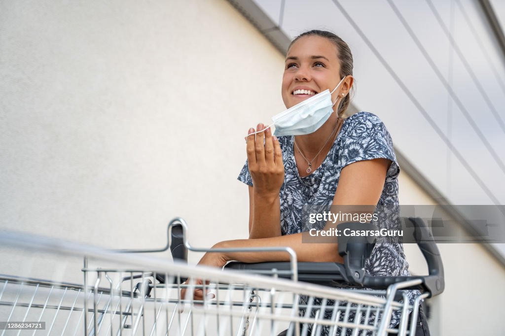 Glimlachende jonge vrouw die een masker van het Gezicht verwijdert en terugkeert om opnieuw te winkelen