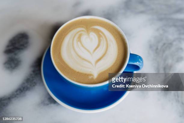 hot chocolate latte in the white coffee cup and marble background. - chocolate top view stock-fotos und bilder