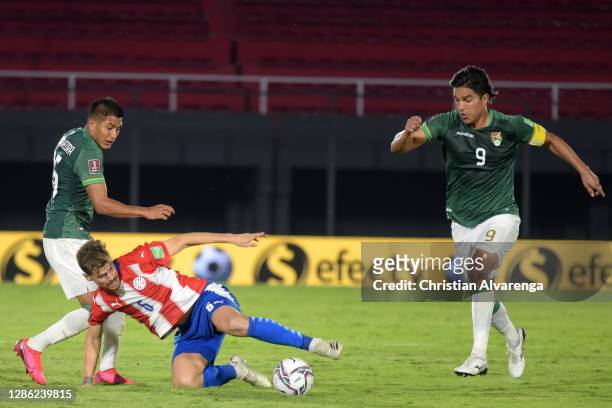 Erwin Saavedra and Marcelo Martins of Bolivia compete for the ball with Gastón Giménez of Paraguay during a match between Paraguay and Bolivia as...