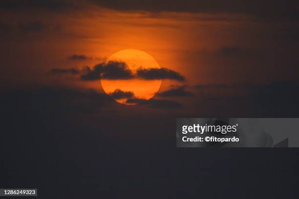 telephoto shot of the sun at sunset near the tropical coast - puerto escondido stock pictures, royalty-free photos & images