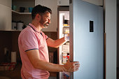 Man searches refrigerator for food