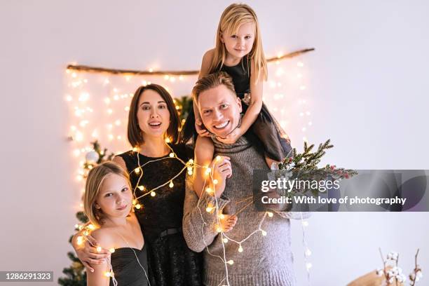 happy european family with two children on christmas indoors at home with traditional christmas decoration - mother and two children feeling good common stockfoto's en -beelden