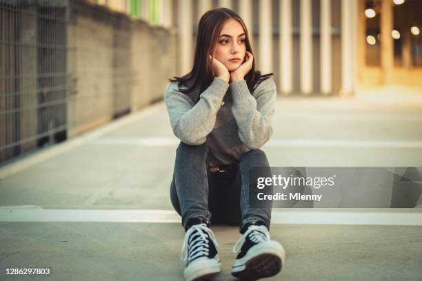 悲しい見た目の日夢 10代の少女は、コンクリートの床に一人で座って - ot ストックフォトと画像