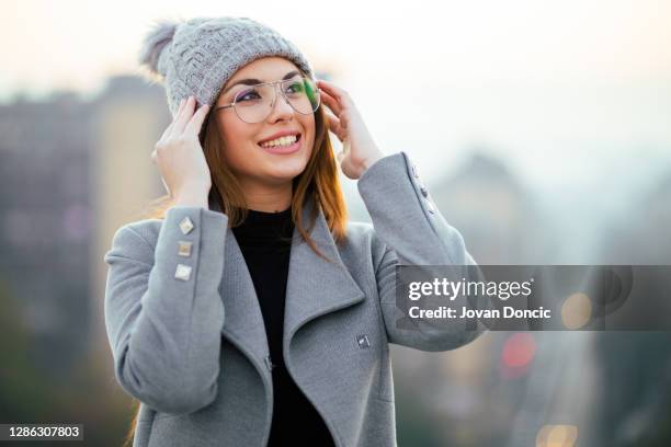 cute smiling girl on rooftop - eyeglasses winter stock pictures, royalty-free photos & images