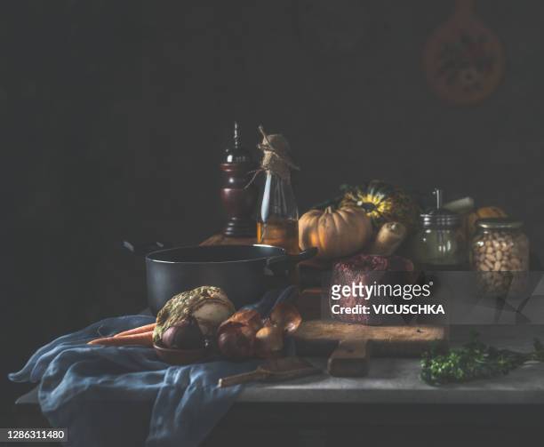 dark rustic kitchen table still life with black cooking pot, bottle of oil and fresh ingredients - 靜物 個照片及圖片檔