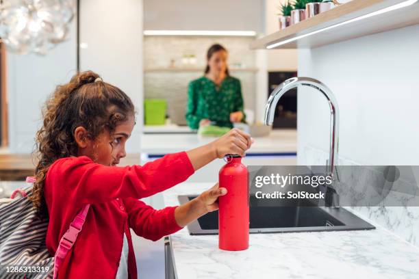 filling up water bottle - water bottles stock pictures, royalty-free photos & images