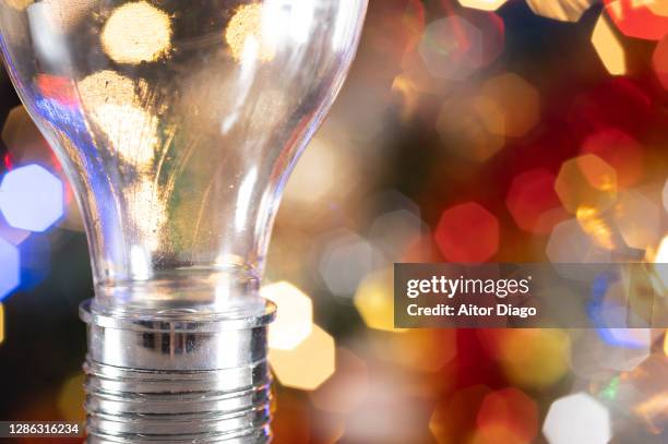 close up of light bulb in a colourful environment. - propriété intellectuelle photos et images de collection