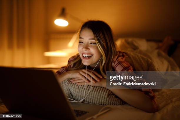 junge frau schaut einen film in der nacht in ihrem schlafzimmer - movie still stock-fotos und bilder