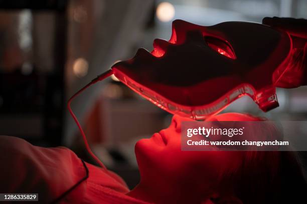 led mask regenerative treatment applied to a young woman. - luce led foto e immagini stock