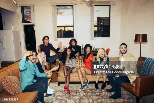 group of friends celebrating while watching television - party imagens e fotografias de stock