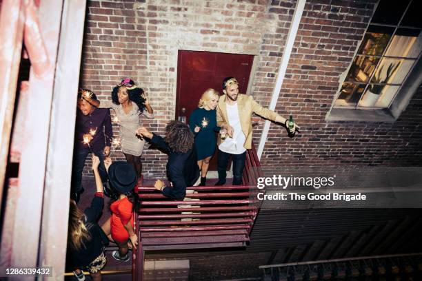 friends enjoying party on balcony at night - balcony party stock pictures, royalty-free photos & images