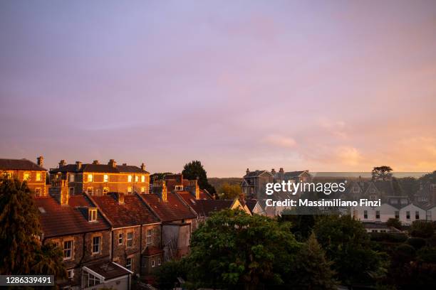 amazing sunset with vibrant pink and yellow colours over the house rooftop of the city of bristol, uk - bristol england photos et images de collection