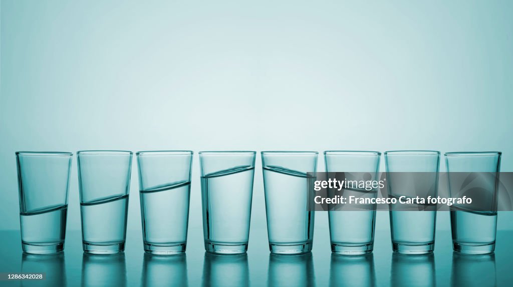 Glasses of water in row.Concept of growth and descending
