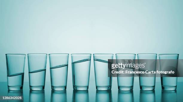 glasses of water in row.concept of growth and descending - full size stock-fotos und bilder