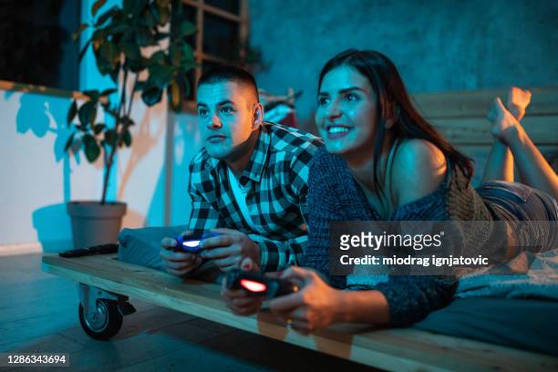 freundin und freund spielen videospiel zusammen in der nacht - couple playful bedroom stock-fotos und bilder