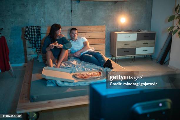 young couple having movie night at home - watching tv couple night stock pictures, royalty-free photos & images